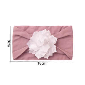 Detail view of pink baby headband with white flower showing 18x9cm size dimensions