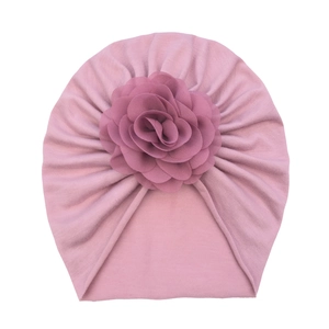 Pink newborn baby turban featuring a large chiffon flower and ribbed stretch fabric detail