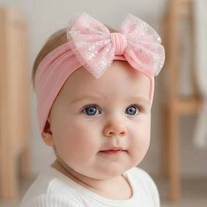 Close-up of pink nylon headband with a large mesh bow on a cute baby girl