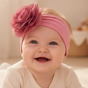 Close-up of baby girl wearing pink floral headband with soft organza petals detail