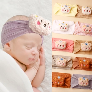 Detail of soft knitted baby headband with cute 3D plush teddy bear and elastic ribbed fabric