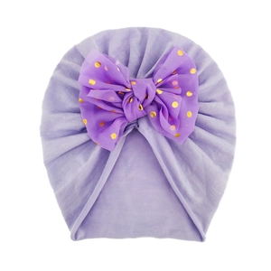 Dettaglio del cappello a turbante per neonati viola con grande fiocco in rete dorata