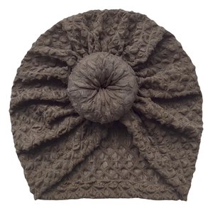 Detailed view of dark brown waffle knit baby donut turban hat with a circular knot