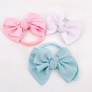 Détail des bandeaux en gros-grain rose, blanc et bleu avec des élastiques doux