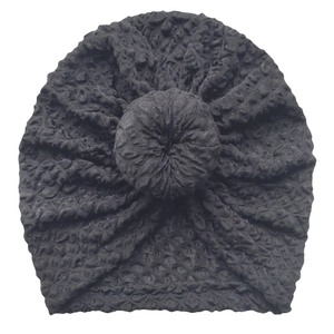 Detailed view of black newborn turban hat with honeycomb texture and donut knot design