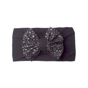 Detail of black elastic baby headband with a large silver sequined polka dot bow tie