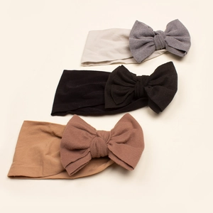 Three-piece baby bow headband set in soft grey, black, and tan colors on white background