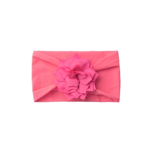 Detail of baby headband featuring soft pink knit fabric and layered floral ornament