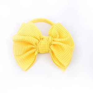 Vue détaillée du bandeau pour bébé en tricot côtelé jaune vif sur un fond blanc neutre