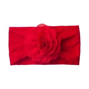 Detail of red elastic baby headband featuring a large layered fabric floral ornament
