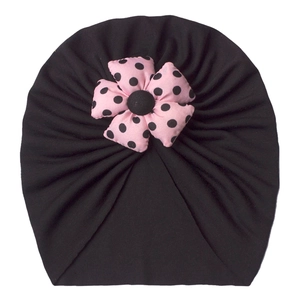 Detail of baby turban hat featuring a pink polka dot fabric flower and pleated knit