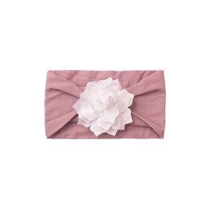 Detailed close-up of a dusty rose baby headband featuring a white 3D fabric flower