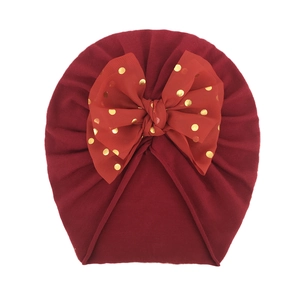 Dettaglio del cappello turban per neonato rosso vino con fiocco in tulle a pois dorati