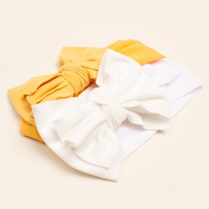 Detailed macro view of ginger and white baby headbands with large double layer bow accents