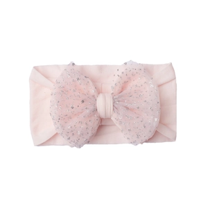Close-up of pink nylon baby headband with sequined mesh bow on a white background