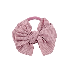 Détail d'un bandeau pour bébé en tissu côtelé rose avec nœud, texture douce et haute élasticité