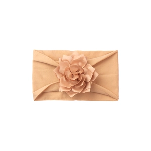 Detail shot of soft apricot baby headband with layered 3D flower and elastic fabric