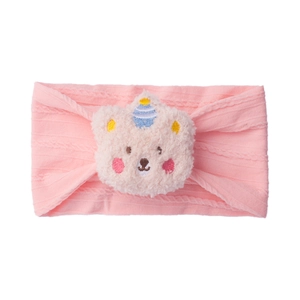 Detail of pink knitted baby headband with cute plush bear and party hat embroidery