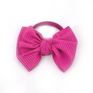 Détail d'un nœud papillon en tissu rose foncé avec bandeau élastique pour bébés et fillettes