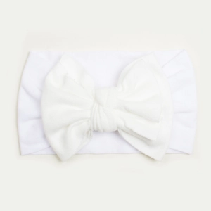 Close-up of a soft white nylon baby headband with a large decorative bow detail