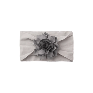 Close-up of soft light grey baby headband featuring a detailed dark grey handmade fabric flower