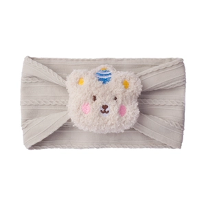 Detail of soft ribbed baby headband with a plush bear character and embroidery