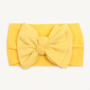 Detailed close-up of a bright yellow knitted nylon baby headband with a large bow