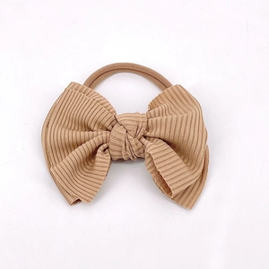 Détail d'un bandeau pour bébé avec un nœud en tissu côtelé beige et nylon souple
