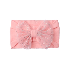 Detail of pink nylon baby headband with sequined mesh bow on a plain white background