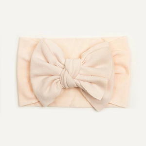 Detail of soft high-elastic nylon baby headband with a large bow in pale pink