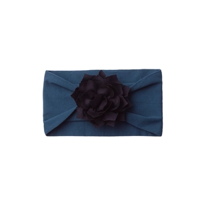 Detail of soft navy blue baby headband featuring a large layered fabric flower decoration