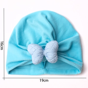 Flat lay of bright blue baby knot hat with bow, size 16x19cm, soft knit fabric