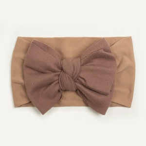 Detailed close-up of baby nylon headband with coffee brown bow on soft ribbed fabric