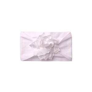 Detail of soft white baby headband featuring a large 3D fabric flower on white background