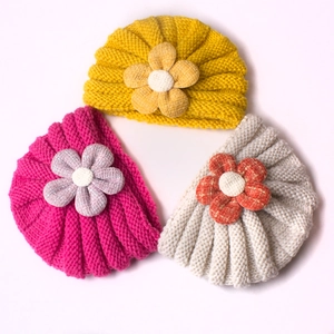 Detailed top view of soft baby turban hats featuring decorative 3D fabric flowers in three colors