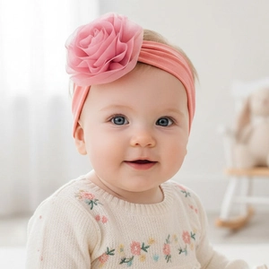 Bandeau bébé en nylon rose doux orné d'une grande fleur en maille délicate