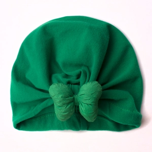 Detail of baby turban hat showing the large bow knot and green soft ribbed fabric texture