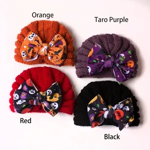 Set of four Halloween baby knit beanies with festive pumpkin and skull bow patterns
