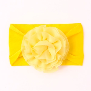 Détail du bandeau bébé jaune vif avec une grande fleur en mousseline et tissu extensible