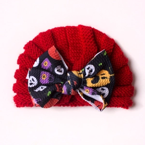 Close-up of red baby knit hat featuring a large Halloween patterned waffle bow