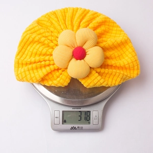 Detailed weight measurement showing the 31.8g yellow infant flower turban hat
