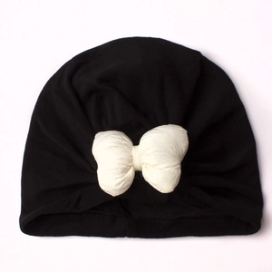 Detailed view of black newborn turban hat with a large white decorative bow knot