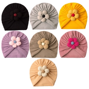 Seven colors of waffle knit baby turban hats with large fabric floral decorations