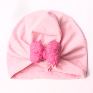 Detail of baby turban hat with large quilted bow and soft knit fabric in pink