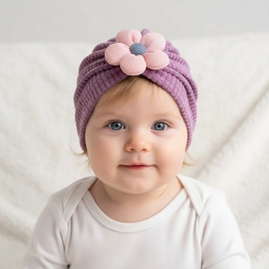Detail of baby winter hat featuring dark purple ribbed knit and 3D floral decoration