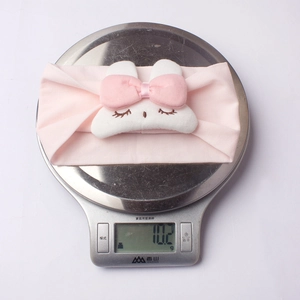 Close-up showing a pink baby headband weighing 10.2g on a scale for comfort