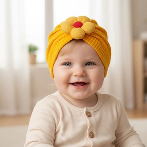 Detailed close-up of a bright yellow knitted baby beanie with a sunflower decoration