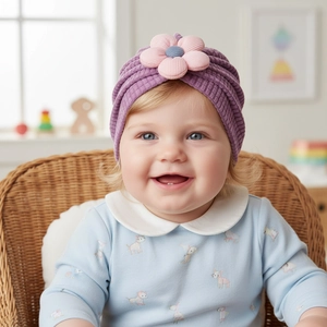 Close-up of baby girl wearing a purple waffle knit beanie with a large pink fabric flower