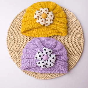 Knit baby beanie hats with large polka dot flowers in bright yellow and light purple colors