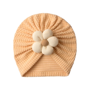 Close-up of soft waffle knit baby turban hat with decorative 3D flower detail